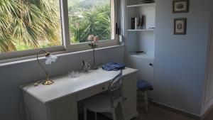 a white desk with a window and a flower on it at The Lakehouse in Vouliagmeni Lake