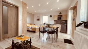 a kitchen and living room with a table and chairs at Eugen Apartmán in Veľký Meder