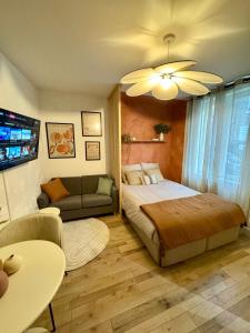 a bedroom with a bed and a couch at Le Nid du Rez in Amiens