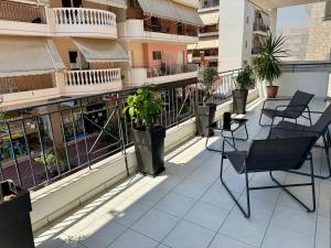a balcony with chairs and plants on a building at Salt & Soul downtown apartment in Mesolongion