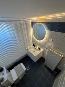 a bathroom with a sink and a toilet and a mirror at Salt & Soul downtown apartment in Mesolongion +4 photos