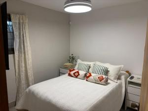 a bedroom with a white bed with pillows on it at Loto San Lorenzo Loft l Piscina & Naturaleza in San Lorenzo +28 photos
