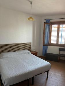 a bedroom with a bed and a window at VistaMare21 in Cala Gonone +3 photos