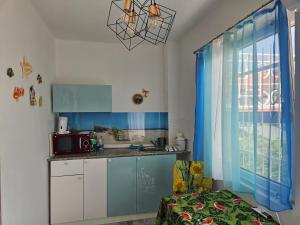 a kitchen with blue and white cabinets and a window at Bagaméri Vendégház in Badacsonytomaj