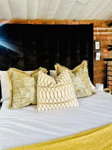 a bed with white sheets and pillows on it at Cozy Luxury apt in Maboneng in Johannesburg