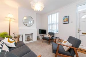 a living room with a couch and a tv at Coal Miners Cottage - Moments To Seafront & Town in Deal