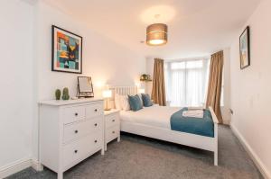 a bedroom with a white bed and a white dresser at Ground Floor Garden Apartment Walpole Bay Margate in Margate +25 photos