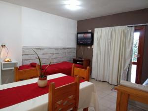 a living room with two beds and a television at Departamento El Nogal in Alta Gracia