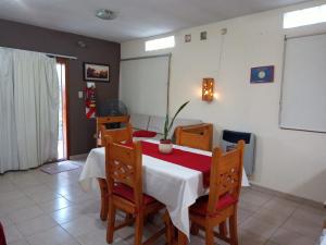 a dining room with a table and chairs with a white table and a white table at Departamento El Nogal in Alta Gracia
