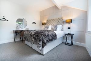 a bedroom with a bed and a desk and a mirror at Lake Road Apartments in Bowness-on-Windermere