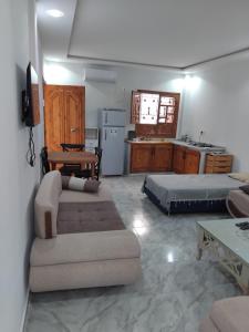 a living room with a couch and a kitchen at Appartement S1 Tulipe in Zarzis