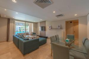 Una sala de estar con un sofá y sillas y una mesa. en Elegant 2BR Plus Nanny Room in Mangroovy Gouna, en Hurghada