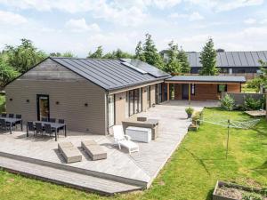a large backyard with a patio and a building at Luxury Spa Retreat - By Traum Ferienwohnungen in Glesborg
