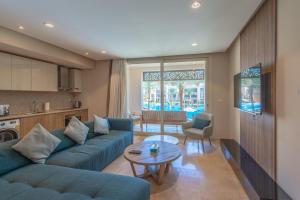 Una sala de estar con un sofá azul y una mesa. en Elegant 2BR Plus Nanny Room in Mangroovy Gouna, en Hurghada