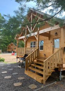 eine große Holzhütte mit einer großen Terrasse in der Unterkunft 2 Bedroom Beach Side Cottage On Muskoka Shores in Parry Sound