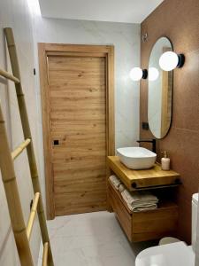 ein Badezimmer mit Holztür und Waschbecken in der Unterkunft Alpha Estudios, Apartamentos turísticos in Astorga