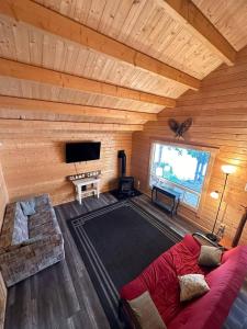 a living room with a red couch in a log cabin at The Pines Cottage on the Lake in Otter Lake