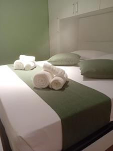 two stacks of towels sitting on top of two beds at Nakupenda B&B in Cosenza +14 photos
