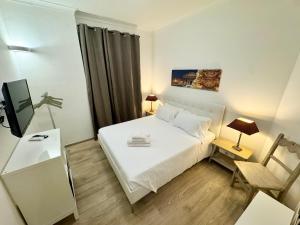 a small bedroom with a white bed and a tv at Mellini Escape in Rome +1 photo