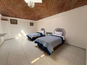 a bedroom with two beds and a chandelier at La Finca Tilhuacán in San Lucas Xoloc