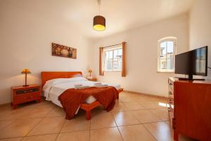 a bedroom with a bed and a flat screen tv at Sea Breeze Guesthouse in Lagos