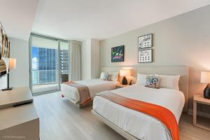 a hotel room with two beds and a window at LYFE Resort Ocean View Penthouse in Hollywood
