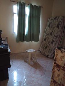 a room with a window and a stool in a room at Apartamento na zona oeste in Padre Miguel