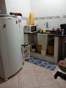 a kitchen with a refrigerator and a sink and a microwave at Apartamento na zona oeste in Padre Miguel