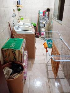 a cluttered bathroom with a sink and a basket at Apartamento na zona oeste in Padre Miguel