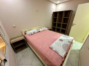 a small bedroom with a bed with a pink blanket at Apartamentos Alborj 6j إقامة البرج in Ifargane