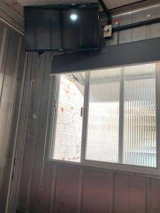 a window in a room with a brick wall at Vila do Chaves Casa Seu Madruga 72 in Itajaí