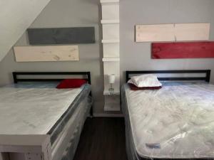 two beds sitting next to each other in a room at Wasaga Beach Loft 4 in Wasaga Beach