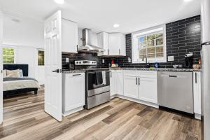 亚特兰大Chic 2BR Bungalow House的配有白色橱柜和不锈钢器具的厨房