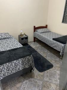 a room with two beds and a table in a room at Recanto da Alegria - Casa em Cunha com Jacuzzi,Piscina,Rede,Churrasqueira,Lareira,Deck, Banco de coração in Cunha