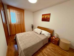 a bedroom with a bed and a table and a window at Apartment in Dramalj 54763 in Dramalj