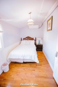 Un dormitorio con una cama blanca y suelo de madera. en Vacation House Washington DC, en Washington