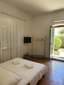a white bedroom with a bed and a large window at Apartments by the sea Vis - 1170 in Vis