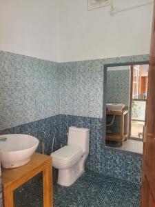 a bathroom with a toilet and a sink and a mirror at Kulathinkal staycation in Trivandrum
