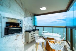 a kitchen with a table and chairs and a large window at Malaga in Guarapari