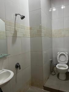 ein Badezimmer mit Toilette und Waschbecken in der Unterkunft Sapo Rumbia Homestay in Berastagi