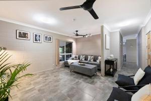 a living room with a couch and a ceiling fan at Nature's Nest - Pool - SPA - Outdoor Kitchen and Dining in Leanyer