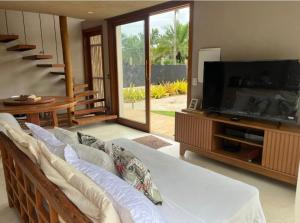 マラウにあるVila Shangrilá Ponta do Mutá, condomínio de charmeのソファと薄型テレビのあるリビングルーム