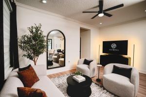a living room with two chairs and a mirror at 3BR Chic Ybor City Tampa Firepit Bikes in Tampa