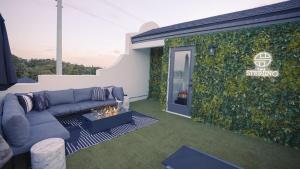 a living room with a couch and a green wall at 3BR-3BA Modern Ybor Central Tampa with Rooftop Firepit & 2 Bikes-Fully Equipped in Tampa