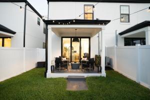 a backyard with a patio with chairs on the grass at 3BR-3BA Modern Ybor Central Tampa with Rooftop Firepit & 2 Bikes-Fully Equipped in Tampa