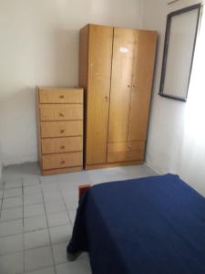 Un dormitorio con una cama azul y armarios de madera. en El descanso, en Pantanillo