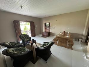 una gran sala de estar con sillas y mesa. en Casa Carvalho em Alter do Chão - Aconchego em meio a natureza, en Santarém 16 fotos más