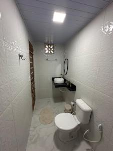 Un baño blanco con inodoro y lavabo. en Casa Carvalho em Alter do Chão - Aconchego em meio a natureza, en Santarém
