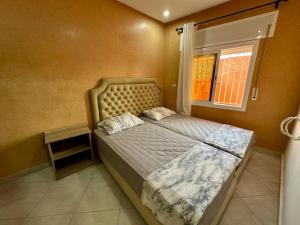 a small bedroom with a bed and a window at Apartamentos Alborj 7J إقامةالبرج in Ifargane