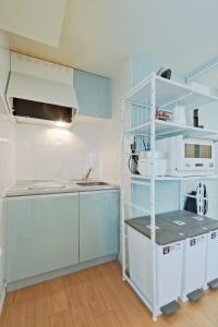 a kitchen with blue cabinets and a white shelf at v close to Noagata 15 min to Shinjuku station in Tokyo